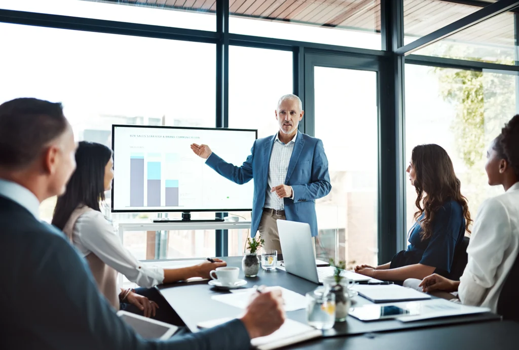 Man presenting to team in meeting.
